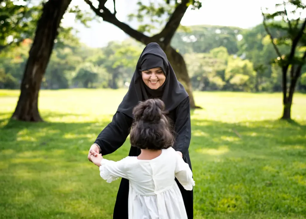 Muslim woman playing with her child wearing chador hijab